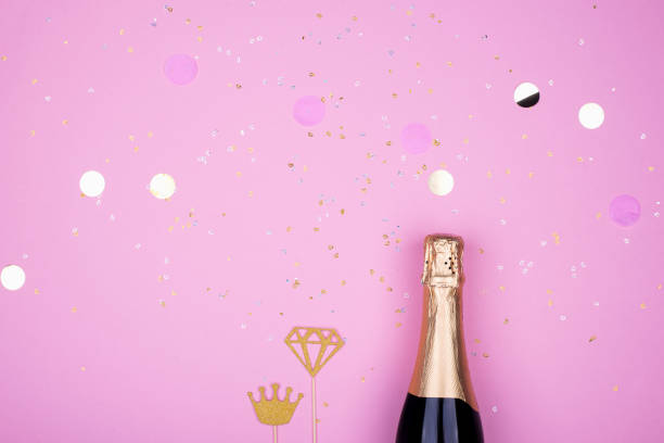 istock champagne candles confetti celebration pastel background. 1137845357