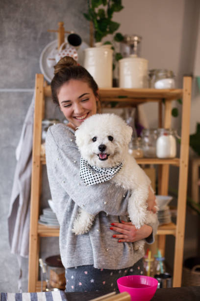 istock Smiling girl with dog in the kitchen 1137846520