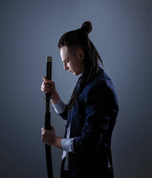 istock Young man holding a samurai sword. Glamour photo. 1137846874