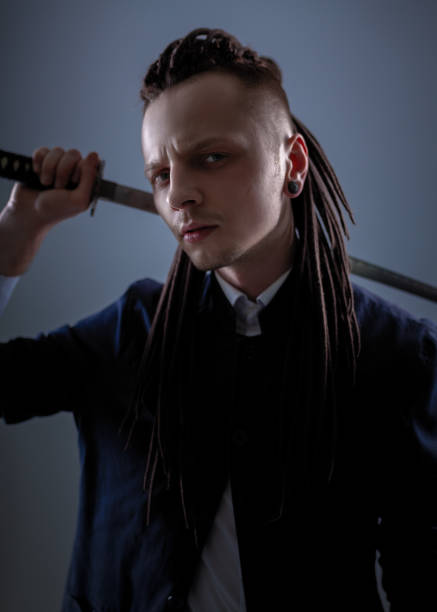 istock Young man holding a samurai sword. Glamour photo. 1137846877