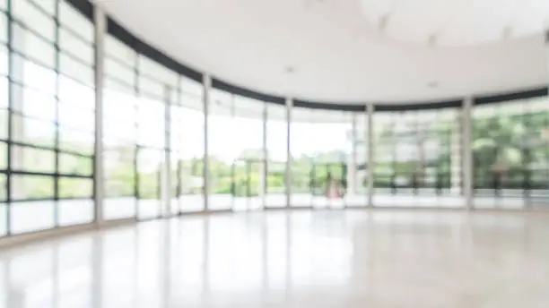 Photo of Office building business lobby blur background with blurry glass window transparent wall interior view inside empty entrance hall