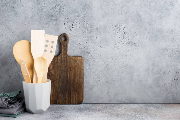 istock Kitchen shelf gray concrete. Ceramic glass with kitchen spoons, spatulas, measuring spoons. Zero waste house. Wood, flax, natural materials.. 1137847271