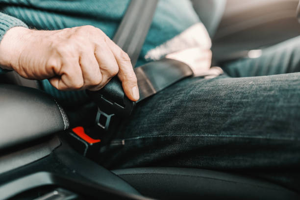 cerca de hombre mayor de la fijación del cinturón de seguridad mientras está sentado en su coche. - men middle senior adult human age fotografías e imágenes de stock