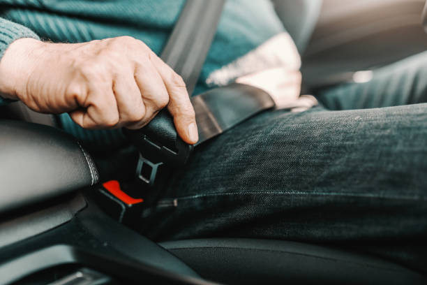 그의 차에 앉아있는 동안 수석 남자 체결 안전 벨트의 클로즈업. - fastening 뉴스 사진 이미지
