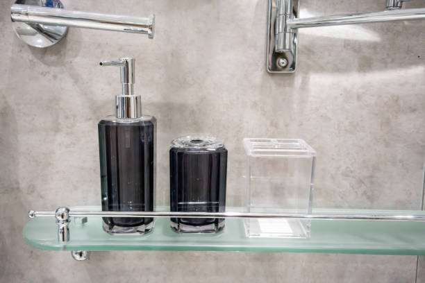 浴室のガラス棚の明確な付属のキットのホールダーによって黒いアクリルディスペンサーのびんおよび歯ブラシのホールダーのセット。 - oil pump ストックフォトと画像