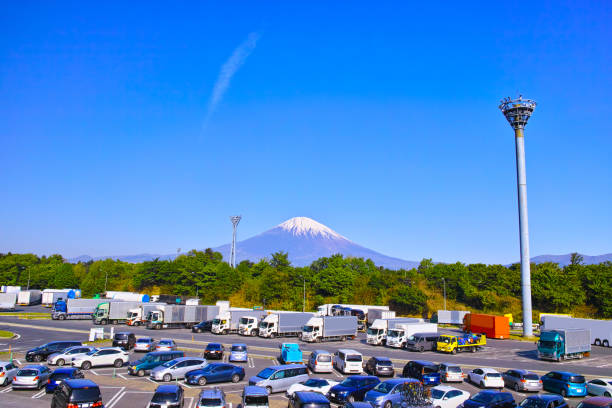 Heavy truck and passenger car parked in the service area of a Japanese highway
