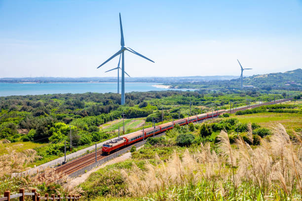 rainway at the coastline with wind turbine stock photo