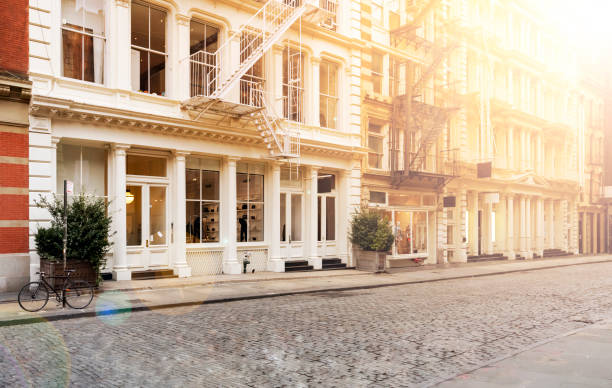 istock Sunlight shines on the empty sidewalks along cobblestone covered Greene Street in the SoHo neighborhood of New York City 1137866341
