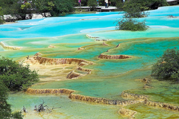 View across multi-colored ponds to boardwalk