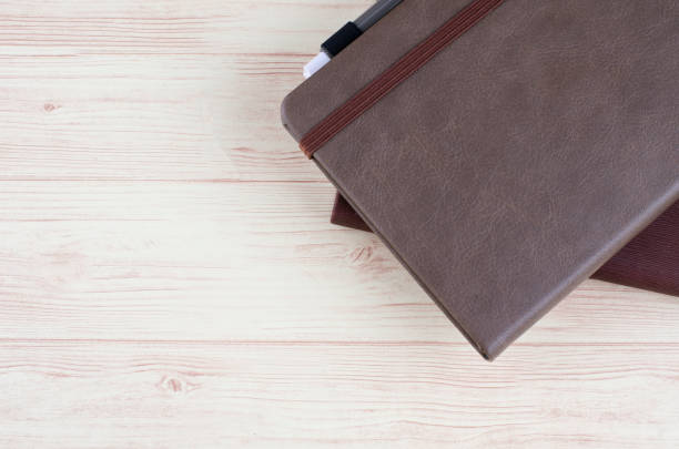 istock Mockup closed diary with pen on wooden background.selective focus shot,copy space for text. 1137872537