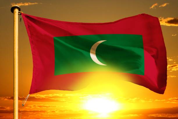 istock Maldives flag weaving on the beautiful orange sunset with clouds background 1137876213