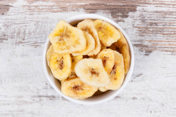 istock Dried organic banana chips on rustic board 1137885101