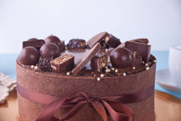 istock Chocolate cake with candy and ribbon on a blue table 1137890437