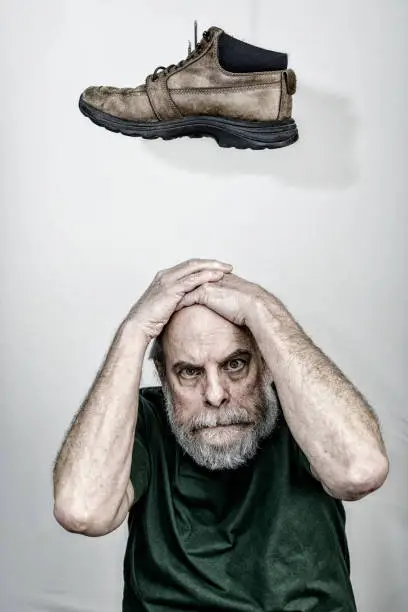 Photo of Superstitious Senior Adult Man Waiting For The Other Shoe To Drop