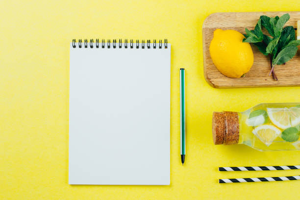 istock White Paper Notebook with empty space and lemonade with ingredients on wooden desk. Flat lay, top view, copy space. Cooking blog, recipe concept 1137892191