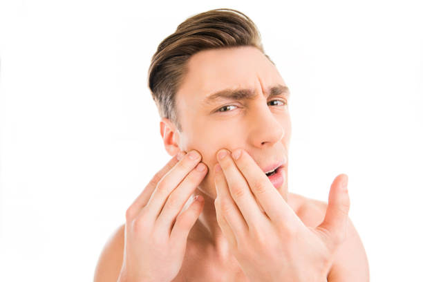 istock Handsome young man touching his face and crushing pimple 1137893101