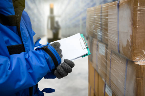 Freezing room or warehouse Closeup shooting hand of worker with clipboard checking goods in freezing room or warehouse cold temperature stock pictures, royalty-free photos & images