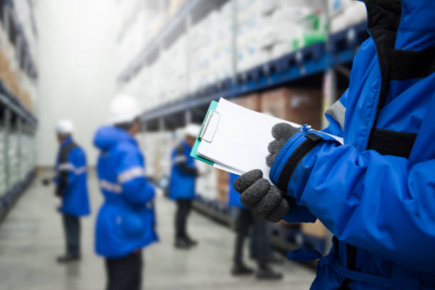 Freezing room or warehouse for Foods Closeup shooting hand of worker with clipboard checking goods in freezing room or warehouse freezer stock pictures, royalty-free photos & images