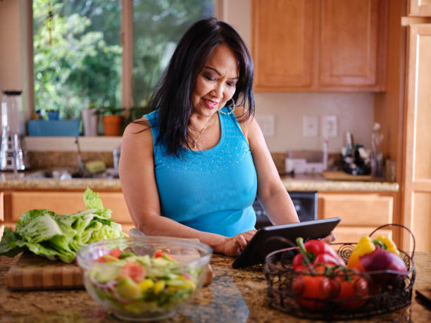 istock elderly thai woman using tablet to follow recipe in kitchen 1137895283