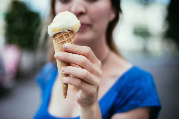 istock Summertime: Young smiling woman is eating ice cream 1137896839
