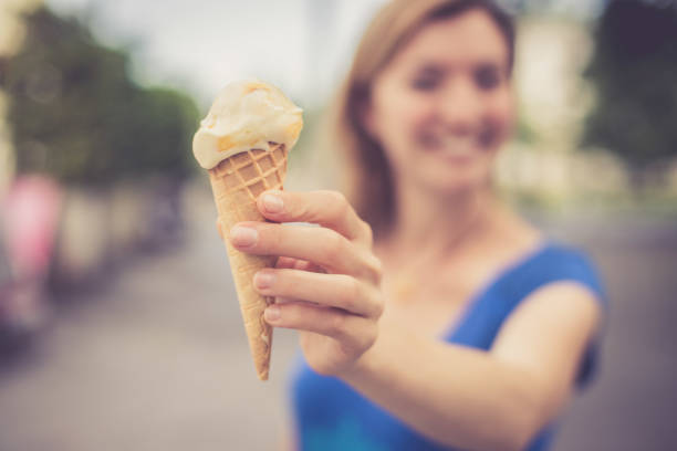 istock Summertime: Young smiling woman is eating ice cream 1137896874