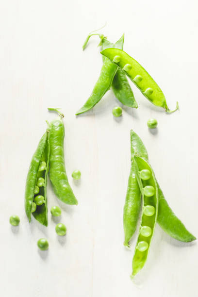 istock Green pea  on the white wooden background 1137897013