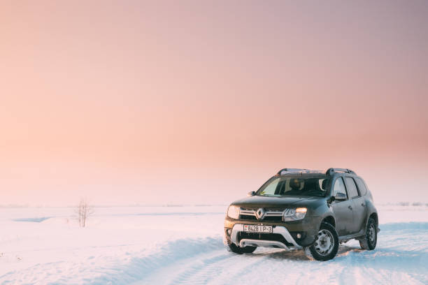 gomel, bielorrusia. coche renault duster o suv dacia duster estacionado en invierno nevada campo en sunset dawn sunrise. - dacia fotografías e imágenes de stock