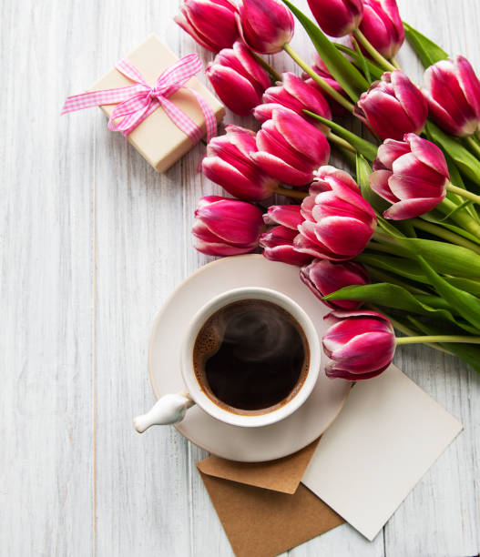 istock Cup of coffee and pink tulips 1137907112