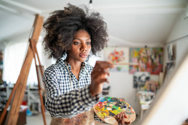 istock Young afro woman drawing 1137914551