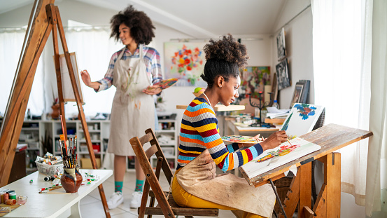 Afro Female fine artists drawing in studio