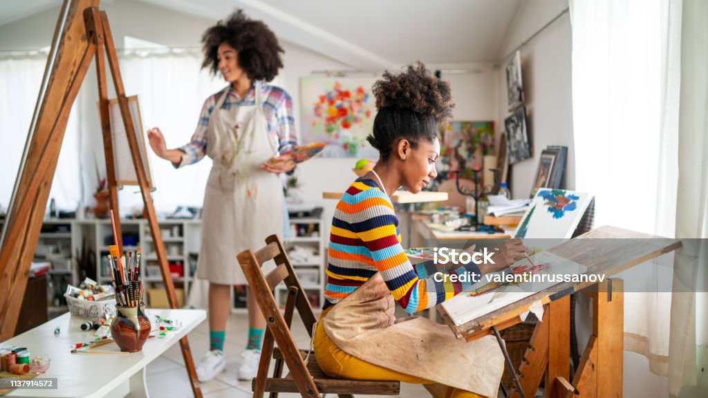 Afro Female fine artists drawing in studio Painting - Activity Stock Photo