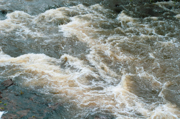istock Background, top view, fast flowing river with dark blue-brown water and white foam waves 1137915809