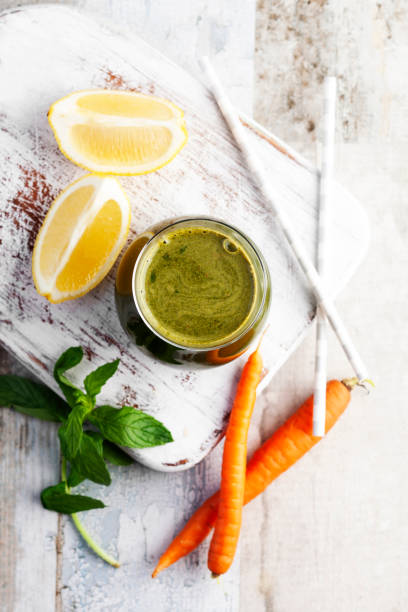 smoothie verde, cenoura smoothie com hortelã, antioxidante, suco de desintoxicação, suco de limão - cold pressed - fotografias e filmes do acervo