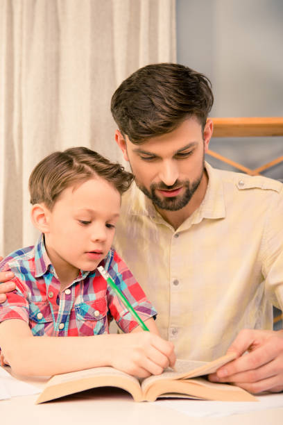 istock Close up portrait of father and son doing home task 1137922677