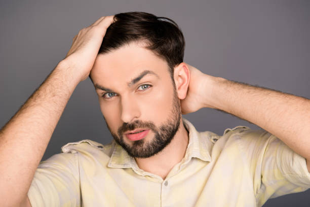 istock Handsome cheerful young man combing his hair with fingers 1137923606