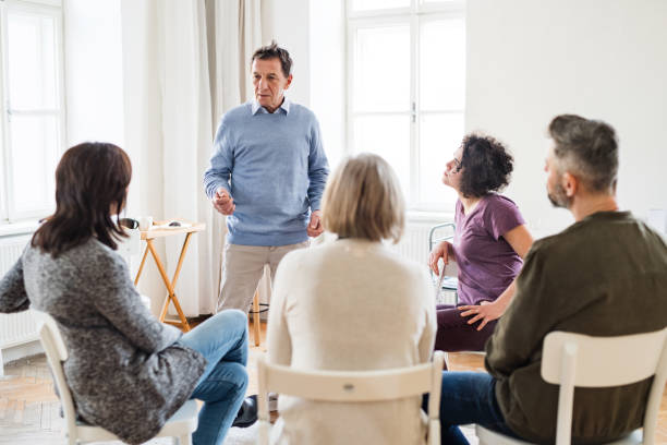 istock A man talking to other people during group therapy. 1137925467