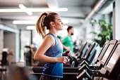 A portrait of young girl or woman doing cardio workout in a gym.