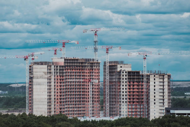 istock Side with cranes against blue sky. High building under construction 1137932495