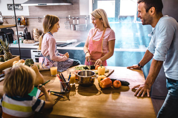 istock Happy parents enjoying while making lunch with their kids in the kitchen. 1137933787