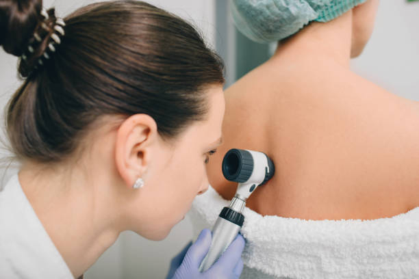 istock dermatologist examines birthmarks on the patient's skin with a dermatoscope 1137934057