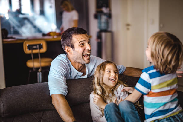 istock Cheerful father having fun while talking to his kids at home. 1137934230