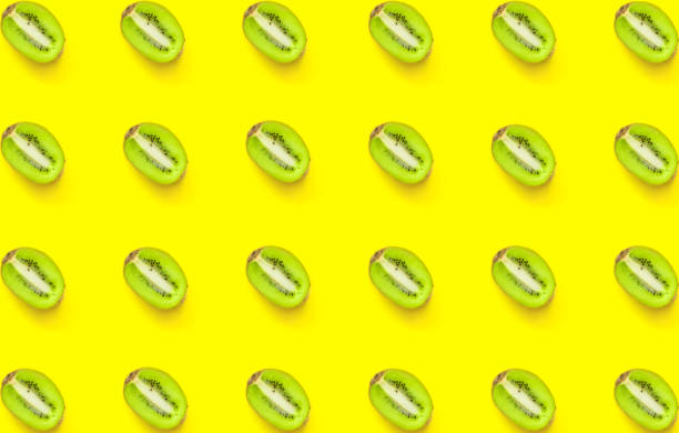 istock Seamless pattern from ripe juicy halved kiwi on yellow background. Creative minimalist flat lay. Vitamins vegan healthy diet tropical vacation fashion concept. Poster wallpaper template 1137935310