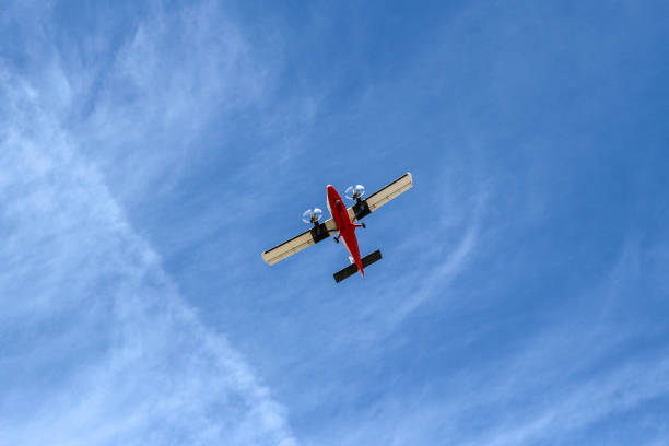 istock Small Airplane Flying at Low Altitude Under Blue Sky Viewed from Below 1137939267