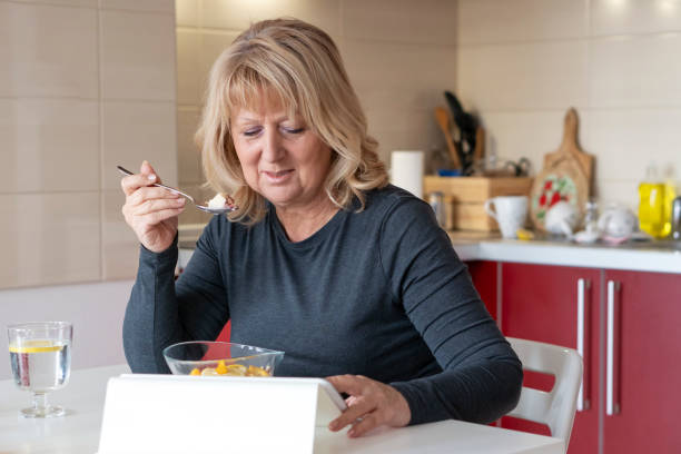istock Senior diabetic Woman having breakfast at home 1137945766