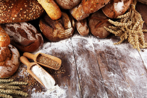 istock Different kinds of bread and bread rolls on board from above. Kitchen or bakery 1137946273