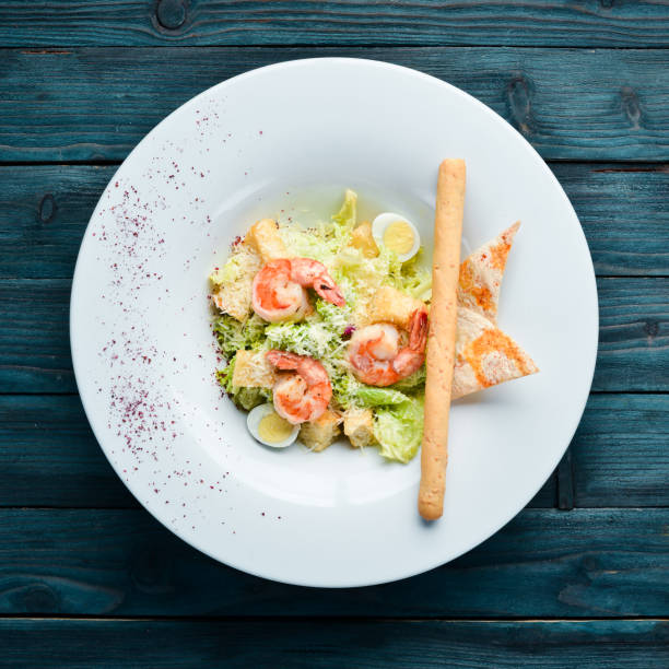 istock Vegetable Caesar Salad with Shrimp. In the plate. Top view. Free space for your text. Rustic style. 1137947545