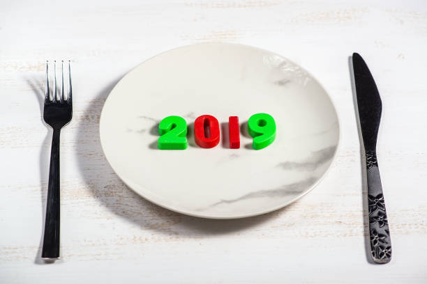 istock Christmas background with a plate and numbers 2019 on a wooden table. 1137954699