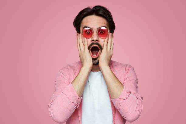 istock Handsome surprised young boy touching bearded face on pink background. 1137960418