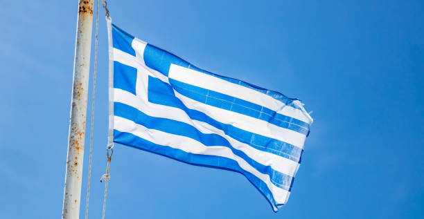 istock Greek flag waving on clear blue sky background 1137962427