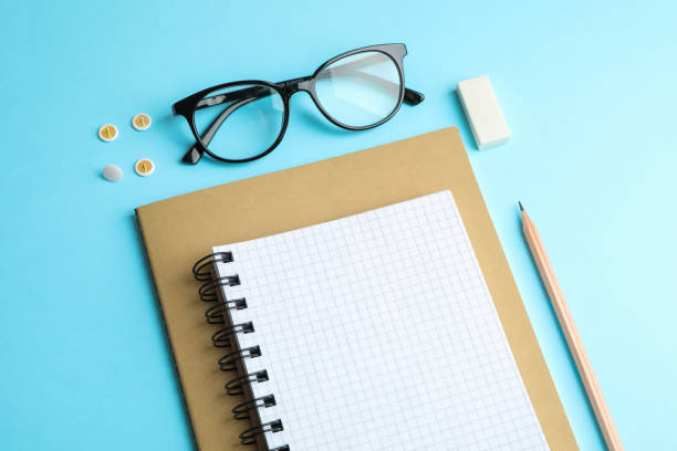 istock Copybooks, pencil and glasses on color background, space for text 1137965366